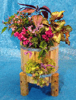 樽型のフラワボックスに季節の花を入れる
